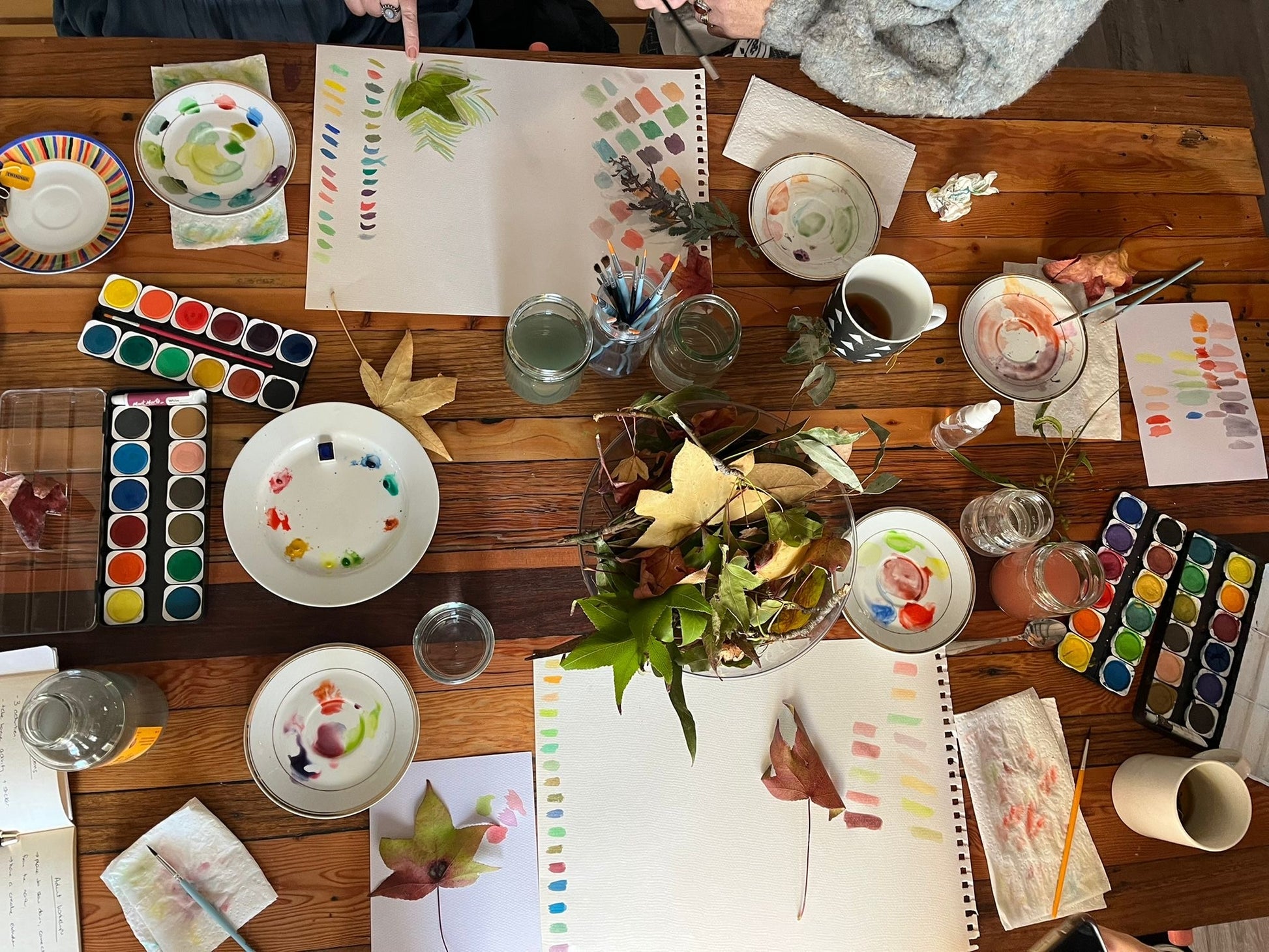 Beginner-friendly cosy watercolour workshop in Wentworthville Sydney with adults and kids painting leaves, flowers, and natural objects while enjoying tea in a relaxed creative studio.